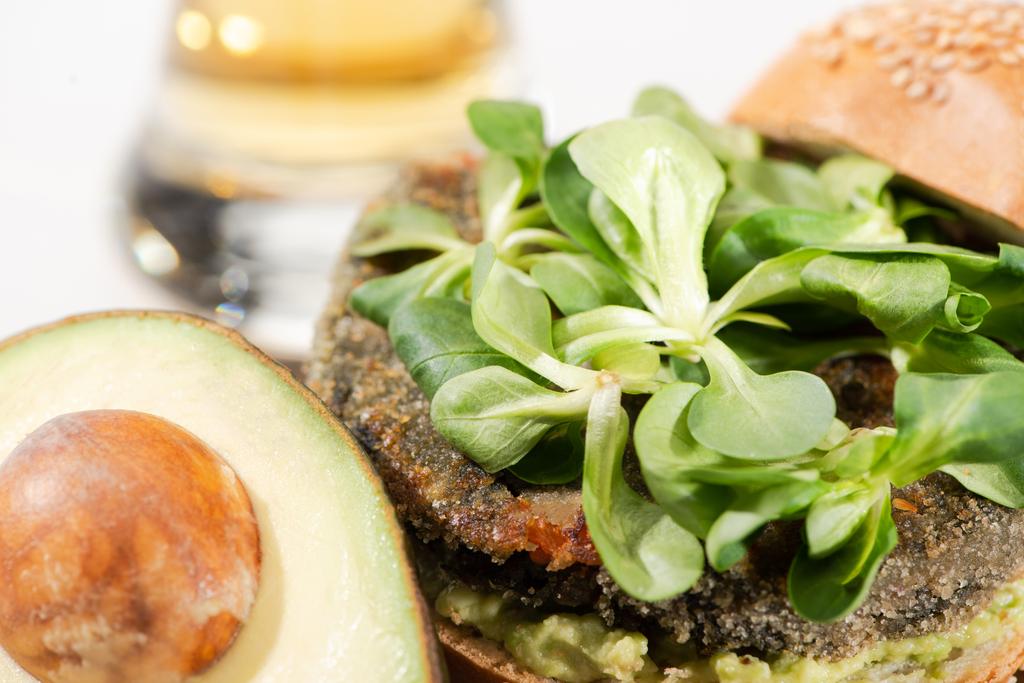 close-up uitzicht op heerlijke groene veganistische hamburger met microgreens, avocado - Foto, afbeelding