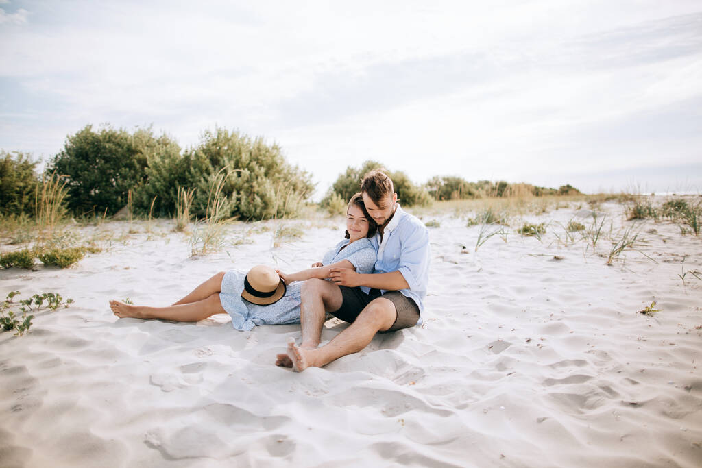 Genç aşık çift deniz sahilinde oturuyor ve hayal kuruyor. - Fotoğraf, Görsel