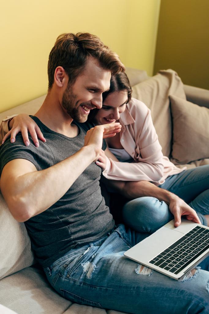 casal feliz assistindo filme e rindo perto do laptop
  - Foto, Imagem