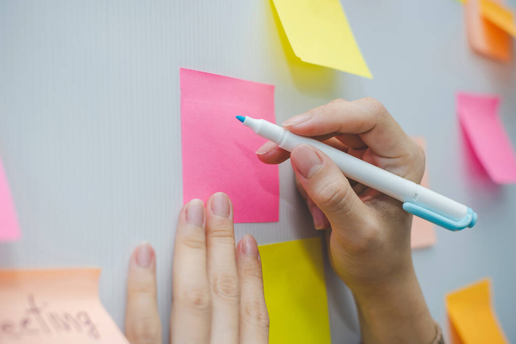 İş kadını el yazısı ve renkli kağıtlar ev ofisinin arka planı üzerine yapışkan not kağıdı, iş toplantısı, beyin fırtınası, yaratıcı, dijital çevrimiçi pazarlama, finansal konsept - Fotoğraf, Görsel