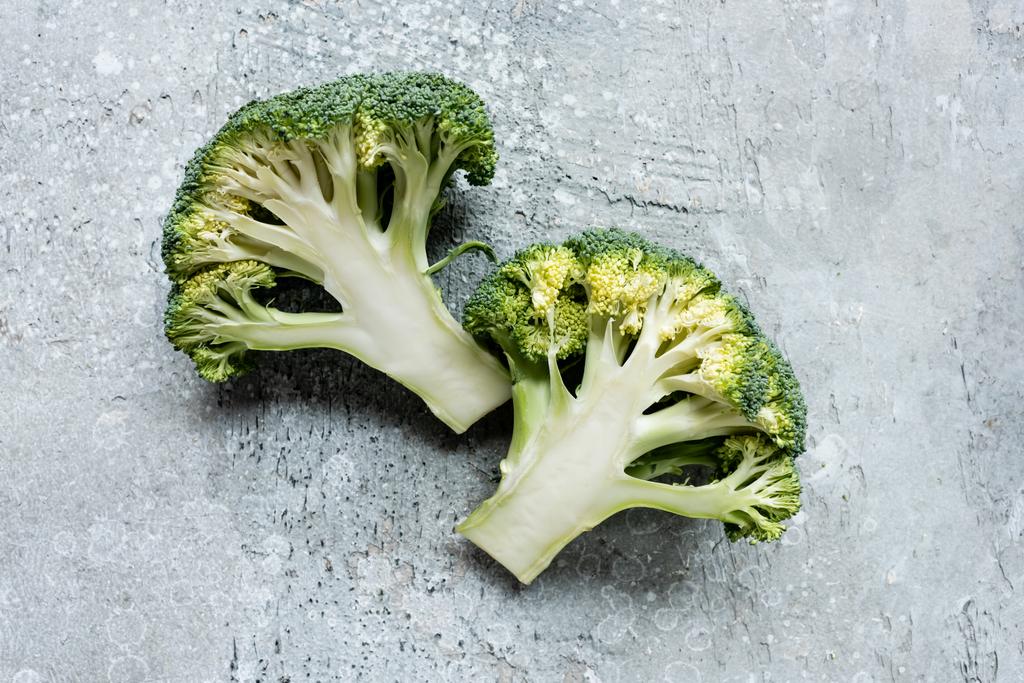 pohled shora na čerstvě zelenou brokolici na šedém povrchu - Fotografie, Obrázek