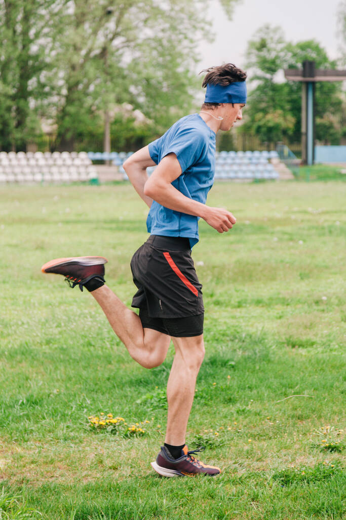 молодой парень бегает утреннюю тренировку на стадионе
 - Фото, изображение