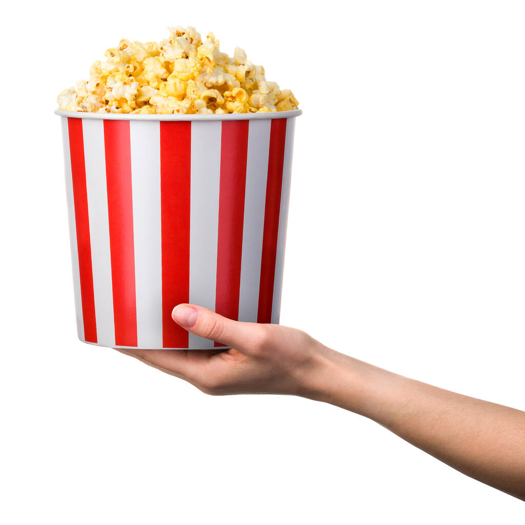 Nainen käsi tilalla raidallinen ämpäri popcorn eristetty valkoisella pohjalla - Valokuva, kuva