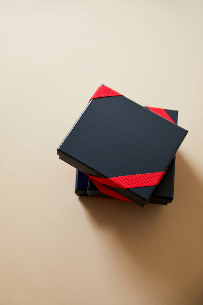 ylhäältä näkymä musta lahja laatikot punainen nauhat beige tausta
  - Valokuva, kuva