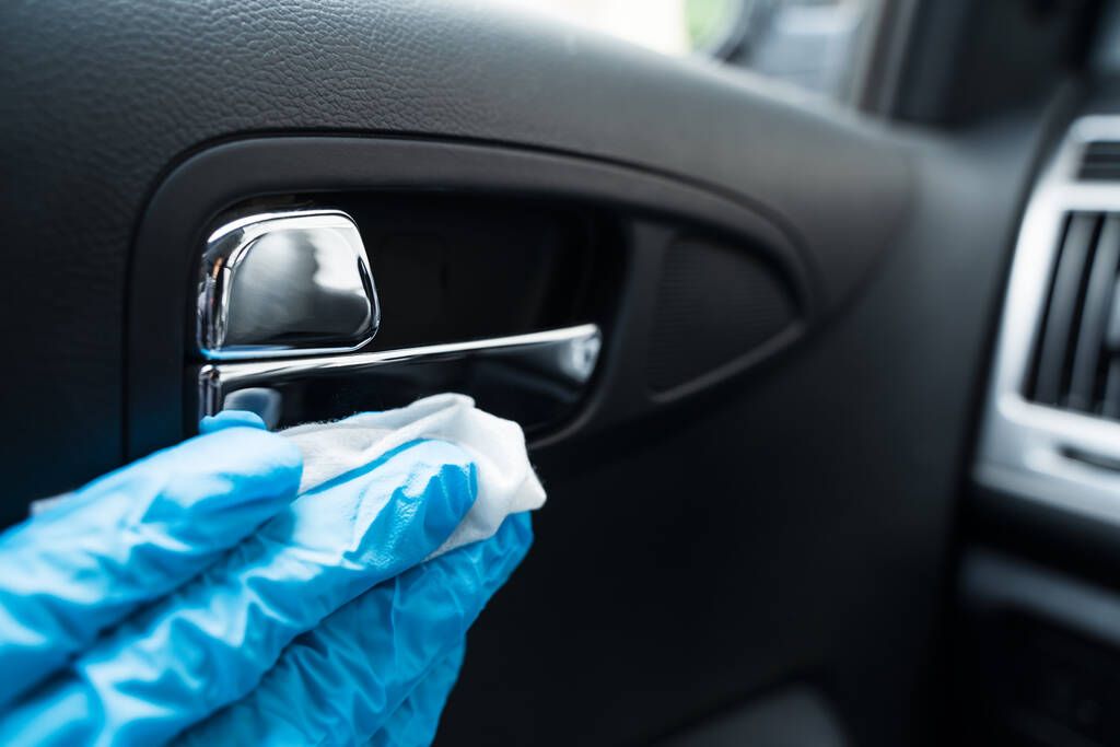 Virüs enfeksiyonuna karşı temizleyici ile araba kapı kolu temizleme - Fotoğraf, Görsel