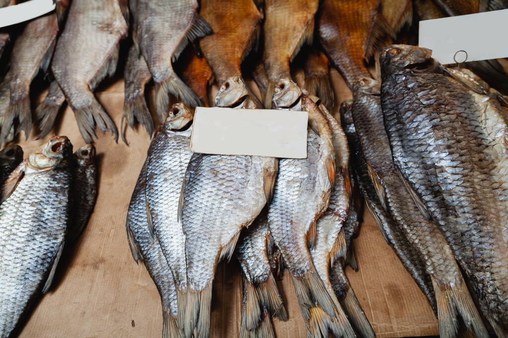 Pazarda balık serisi. Bir grup kurutulmuş balık koçu tezgahın üzerinde duruyor. - Fotoğraf, Görsel