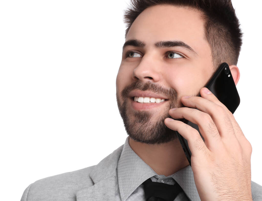 Nuori liikemies puhuu älypuhelimella valkoista taustaa vasten
 - Valokuva, kuva