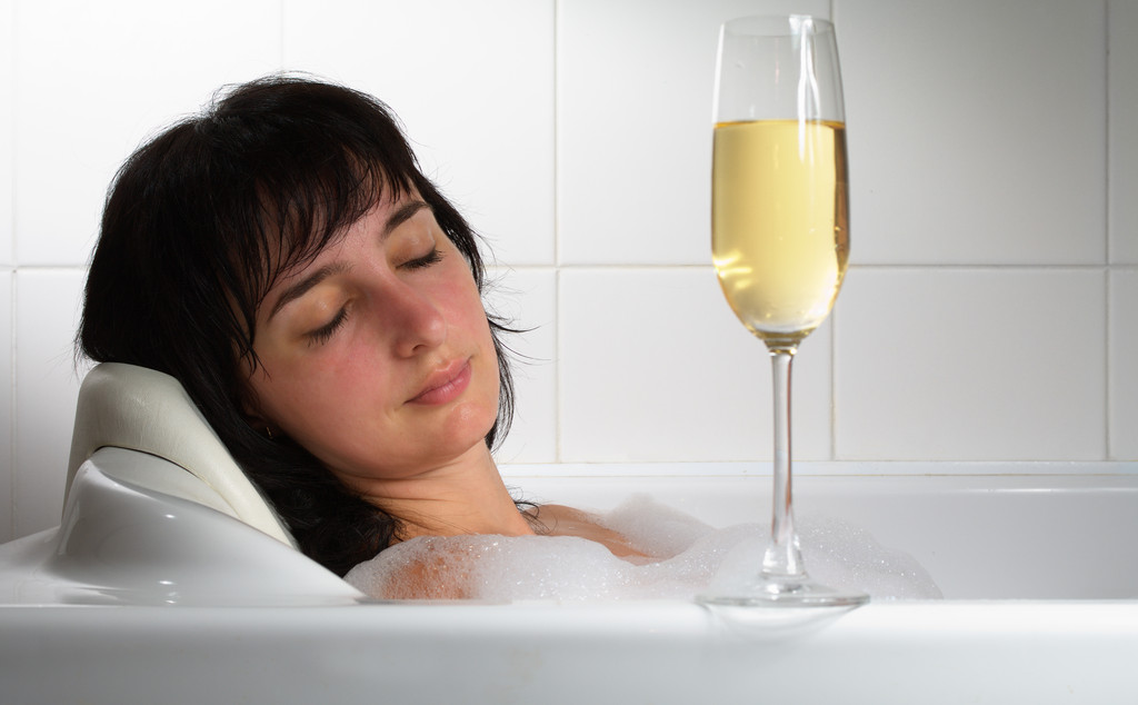 シャンパン グラスでお風呂で寝ている女性 - 写真・画像