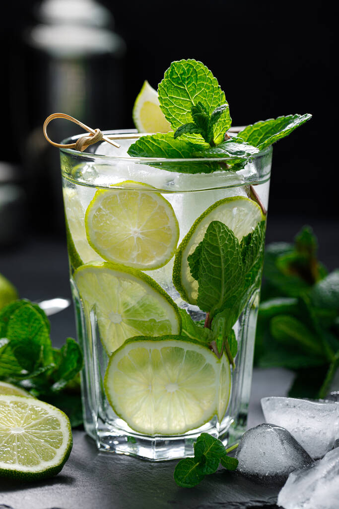 Frissítő nyári alkoholos koktél mojito jéggel, friss mentával és lime-mal - Fotó, kép