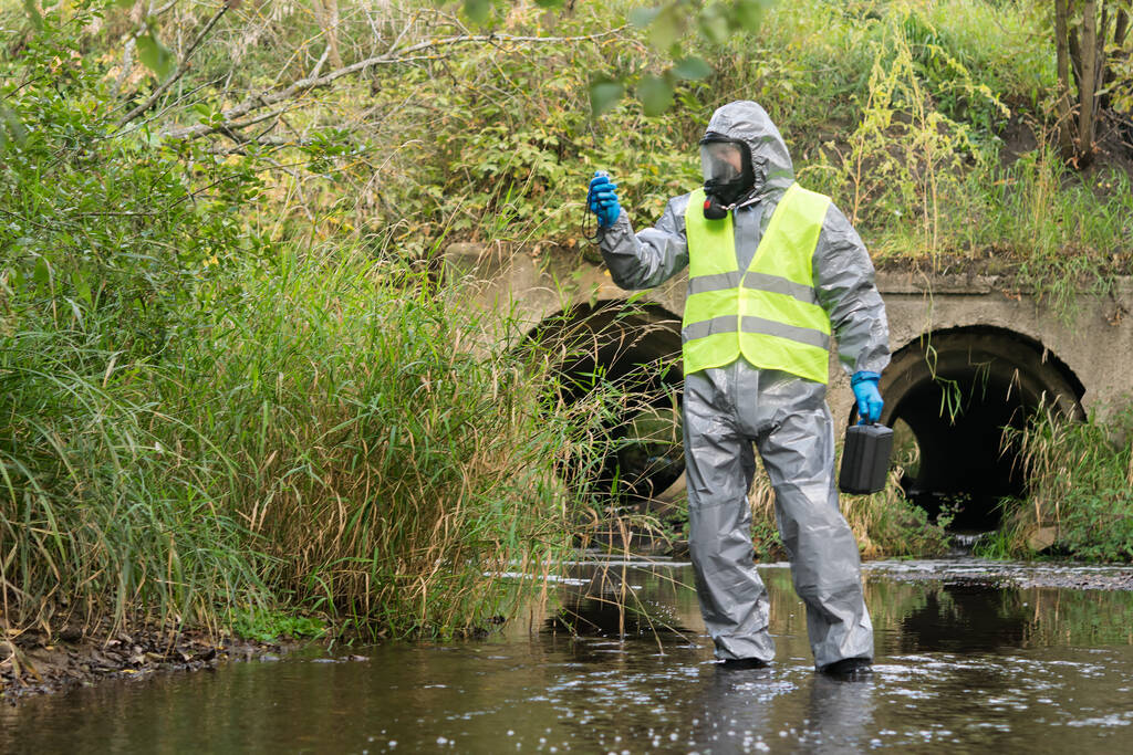 野外特別保護服の研究室の助手は装置との環境汚染のレベルを測定します - 写真・画像