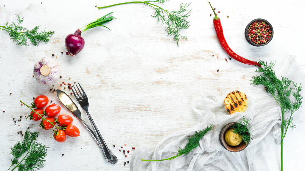 Weiße Küche Hintergrund. Küchenbrett, Gemüse und Gewürze auf weißem Holzgrund. Ansicht von oben. - Foto, Bild