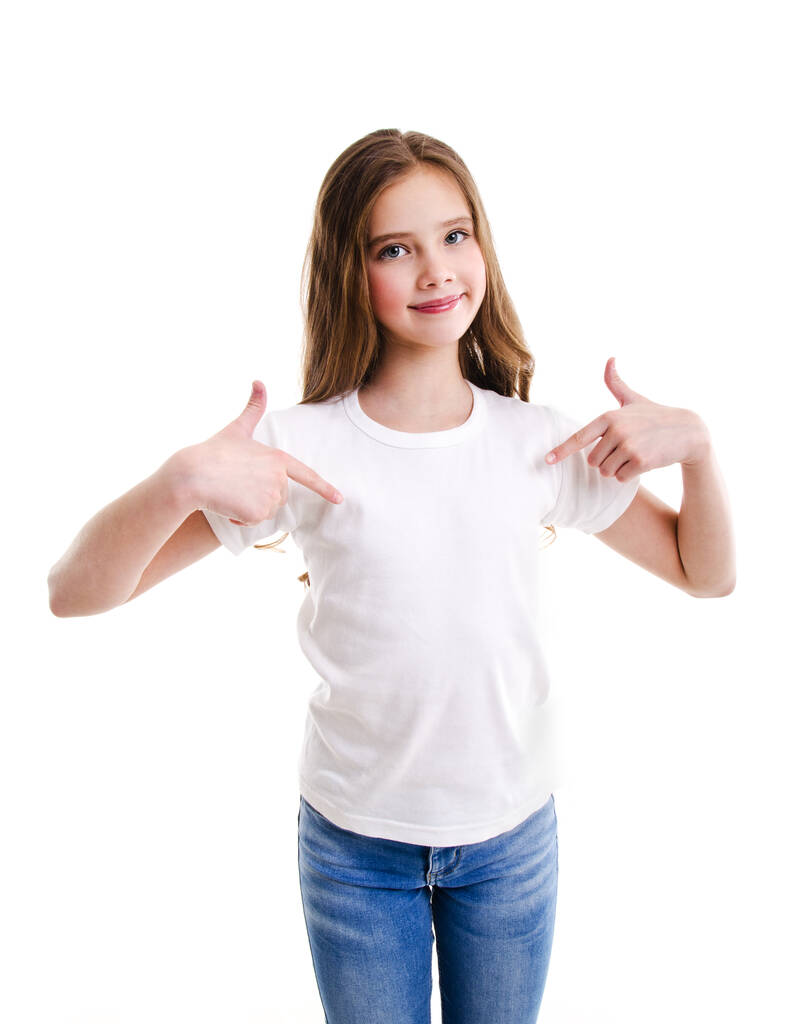 Beyaz tişörtlü, sevimli gülümseyen küçük kız çocuğu portresi beyaz arka planda izole edilmiş işaret parmaklarıyla kendini gösteriyor. - Fotoğraf, Görsel