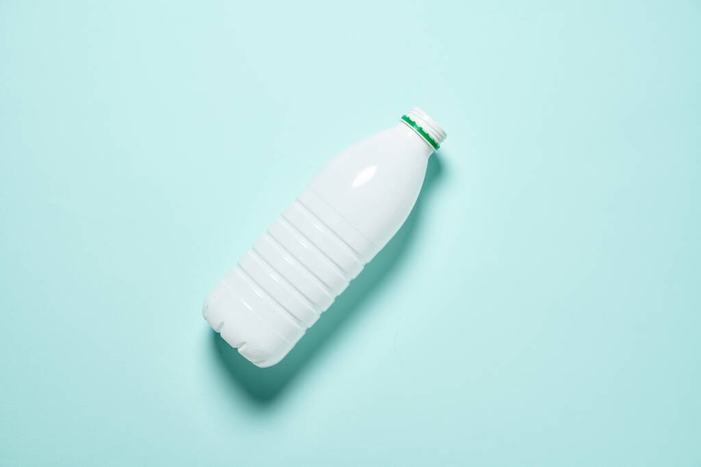 Bílá plastová láhev přes zelené pozadí - Fotografie, Obrázek