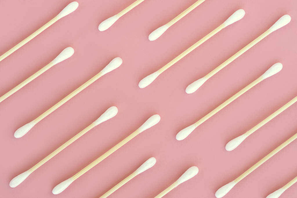 Muster aus Wattestäbchen auf rosa Hintergrund. Ansicht von oben. - Foto, Bild