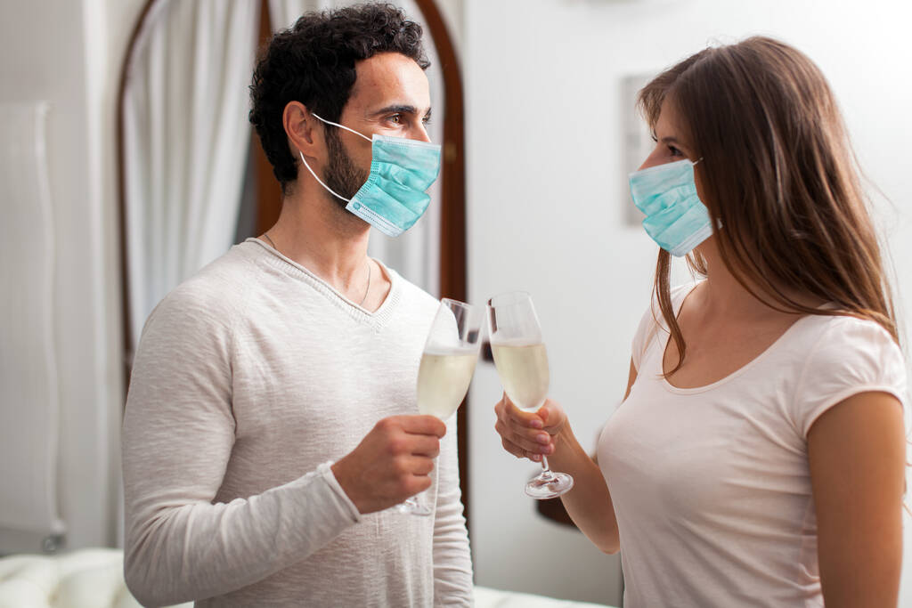 Muž a žena nosí masky přípitek se šampaňským - Fotografie, Obrázek