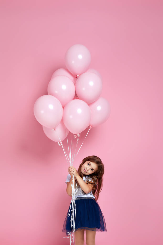 enfant fille posant avec des ballons à air rose pastel
 - Photo, image