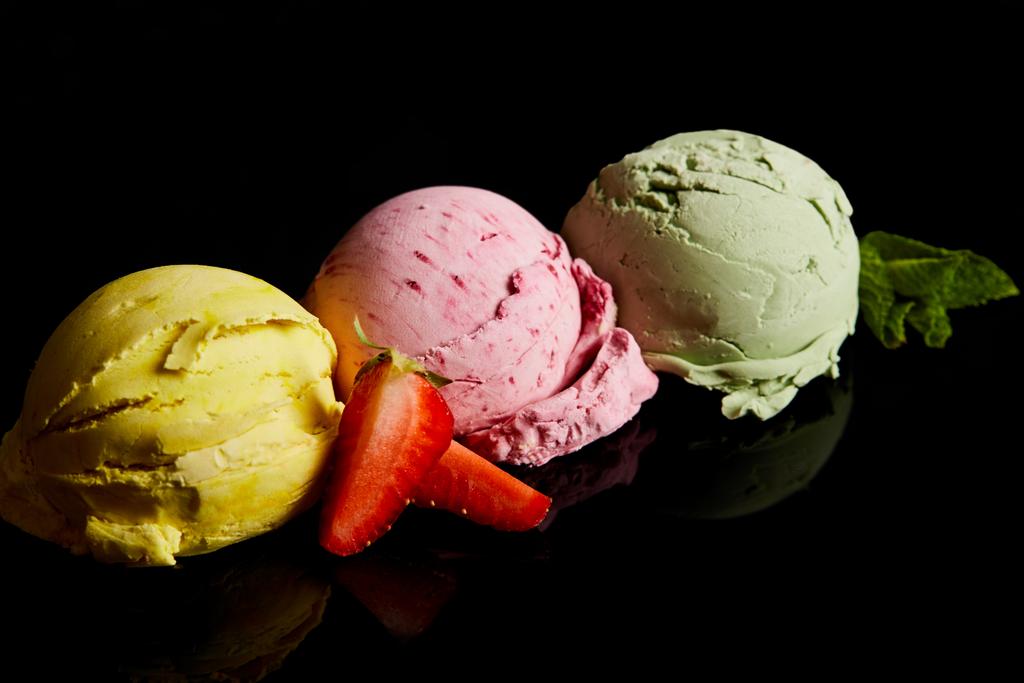 délicieuses boules de crème glacée citron, fraise et menthe isolées sur noir
 - Photo, image