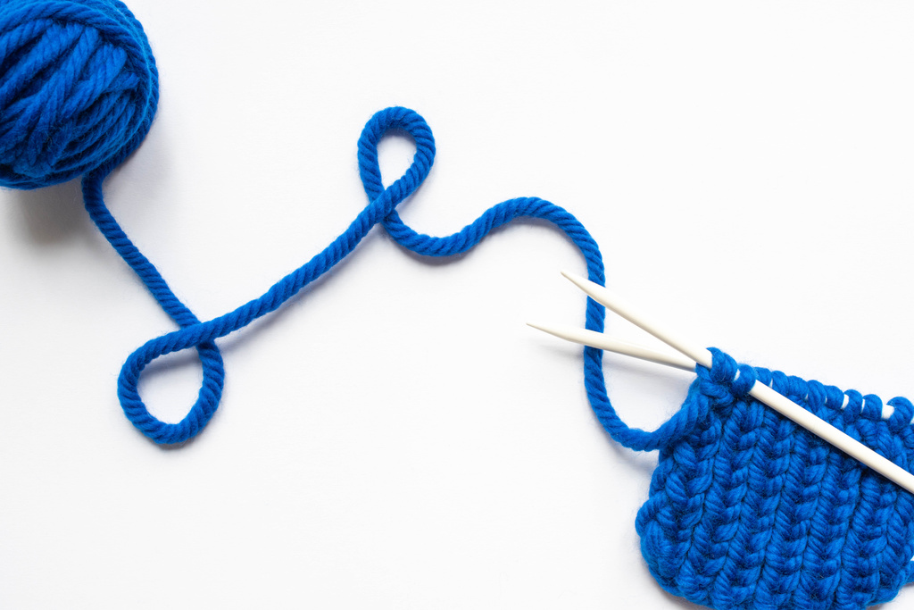 vue du dessus des fils de laine bleue et des aiguilles à tricoter sur fond blanc
 - Photo, image