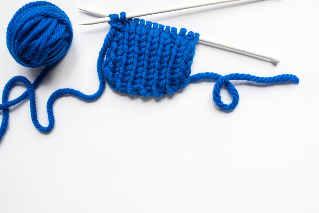 vista superior del hilo de lana azul y agujas de punto sobre fondo blanco
 - Foto, Imagen