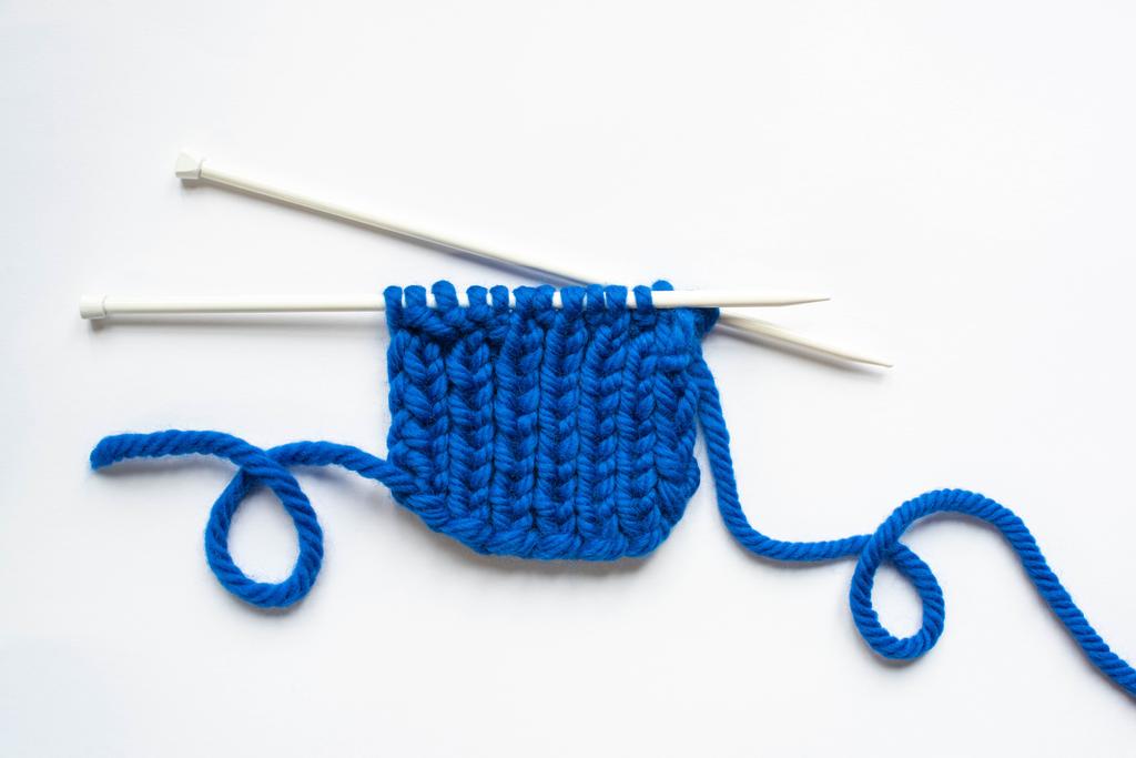 白い背景に青い毛糸と編み針のトップビュー - 写真・画像