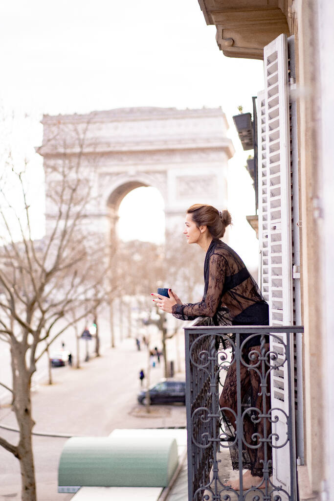 Atraktivní jang žena v pyžamu pije kávu na balkóně  - Fotografie, Obrázek