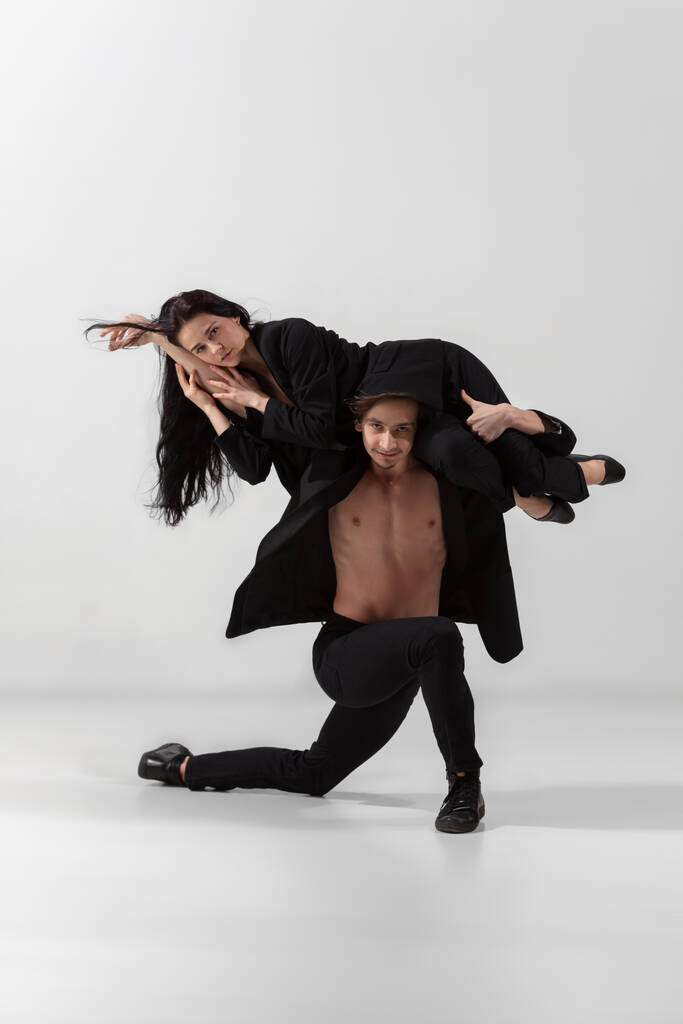 Fiatal és kecses balett táncosok minimális fekete stílusban elszigetelt fehér stúdió háttér - Fotó, kép