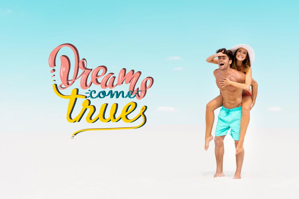 smiling young man piggybacking girlfriend on sandy beach, dreams come true illustration - Photo, Image