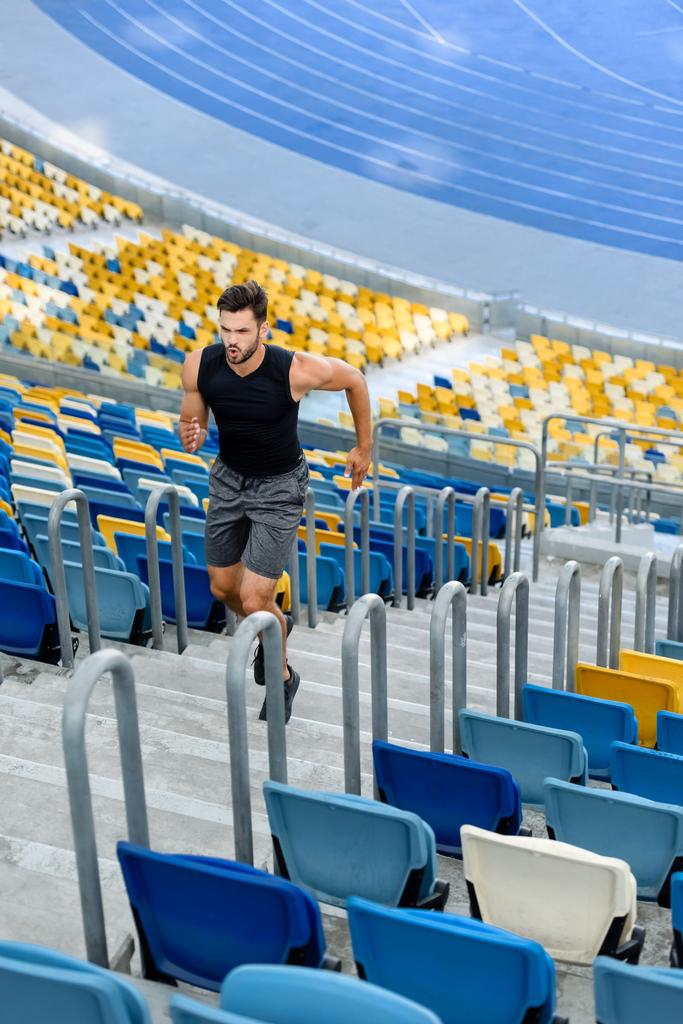 young sportsman running on stairs at stadium - Photo, Image
