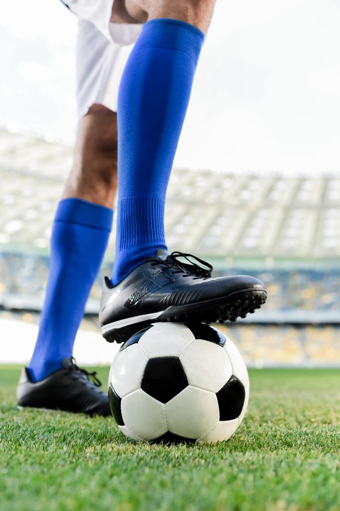 jambes de footballeur professionnel en chaussettes bleues et chaussures de football sur le ballon au stade
 - Photo, image