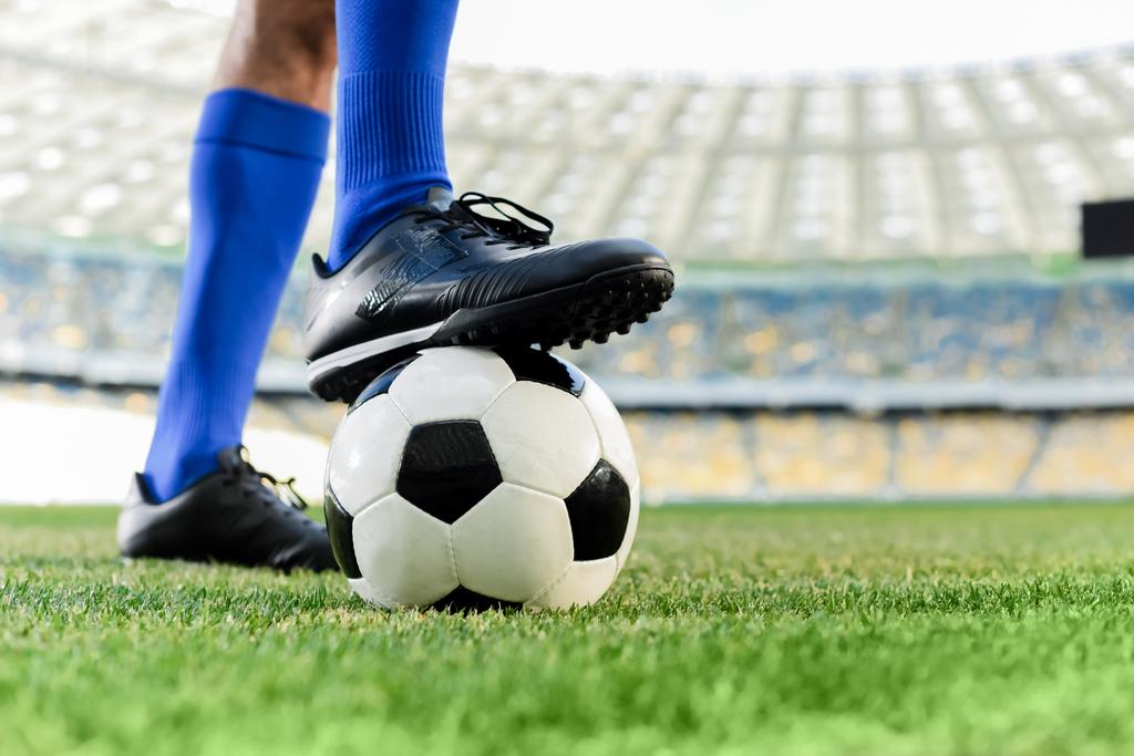 nogi profesjonalnego piłkarza w niebieskich skarpetkach i buty do piłki nożnej na stadionie - Zdjęcie, obraz