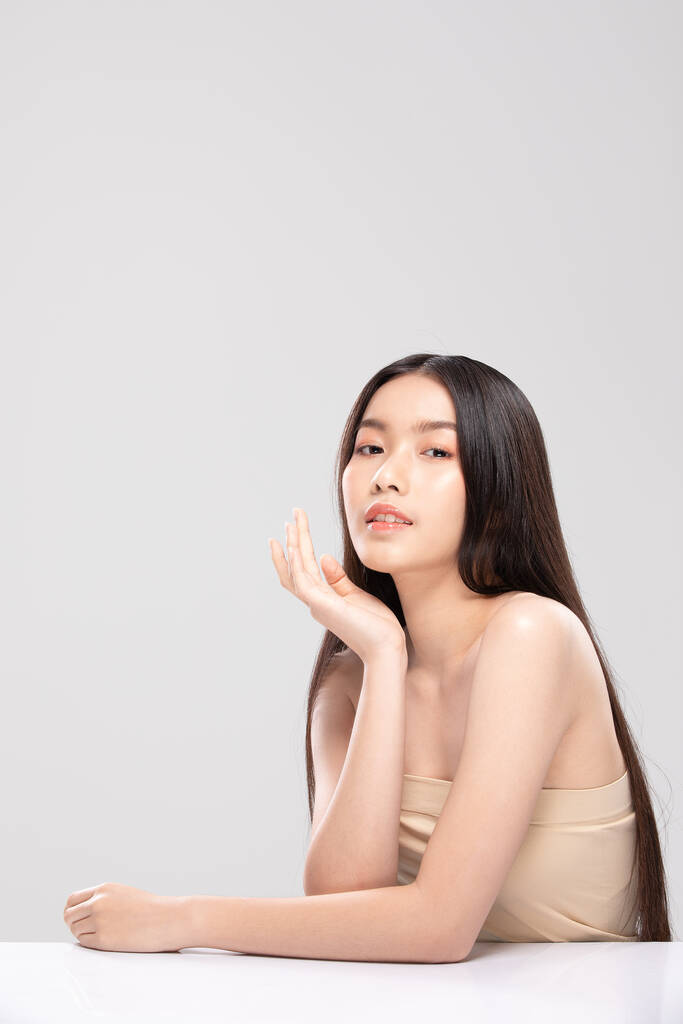 Schöne asiatische junge Frau berührt weiches Wangenlächeln mit sauberer und frischer Haut Glück und fröhlich mit positiven emotionalen, isoliert auf weißem Hintergrund, Schönheits- und Kosmetikkonzept - Foto, Bild
