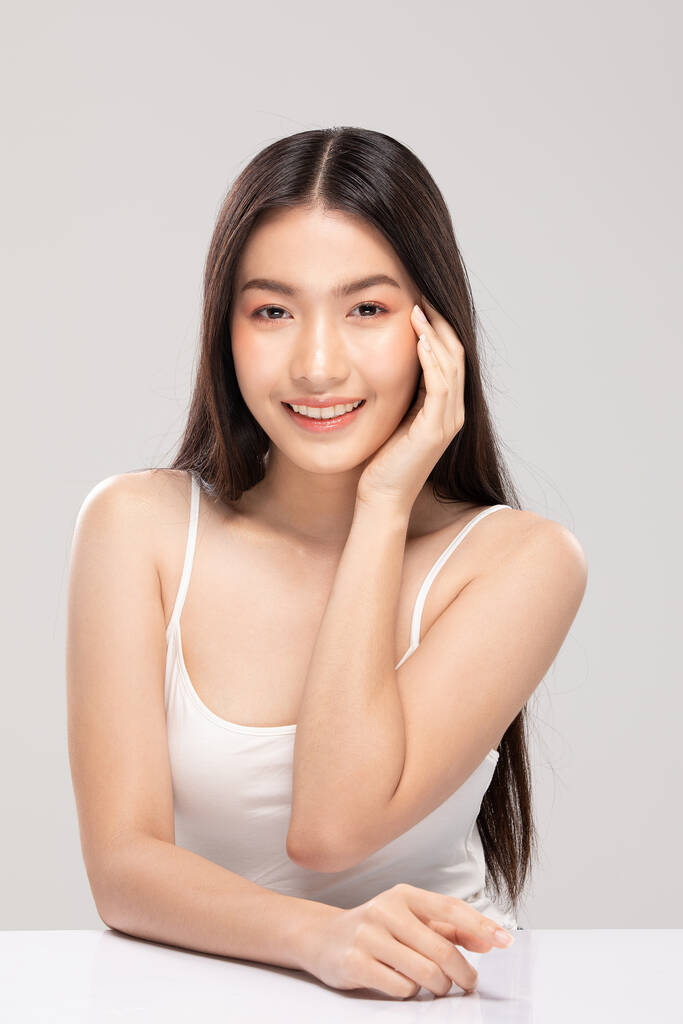 Kaunis aasialainen nainen koskettaa pehmeää poskea hymyillen puhtaalla ja tuoreella iholla Onnellisuus ja iloinen positiivisella emotionaalisella, eristetty valkoisella taustalla, kauneus ja kosmetiikka käsite - Valokuva, kuva