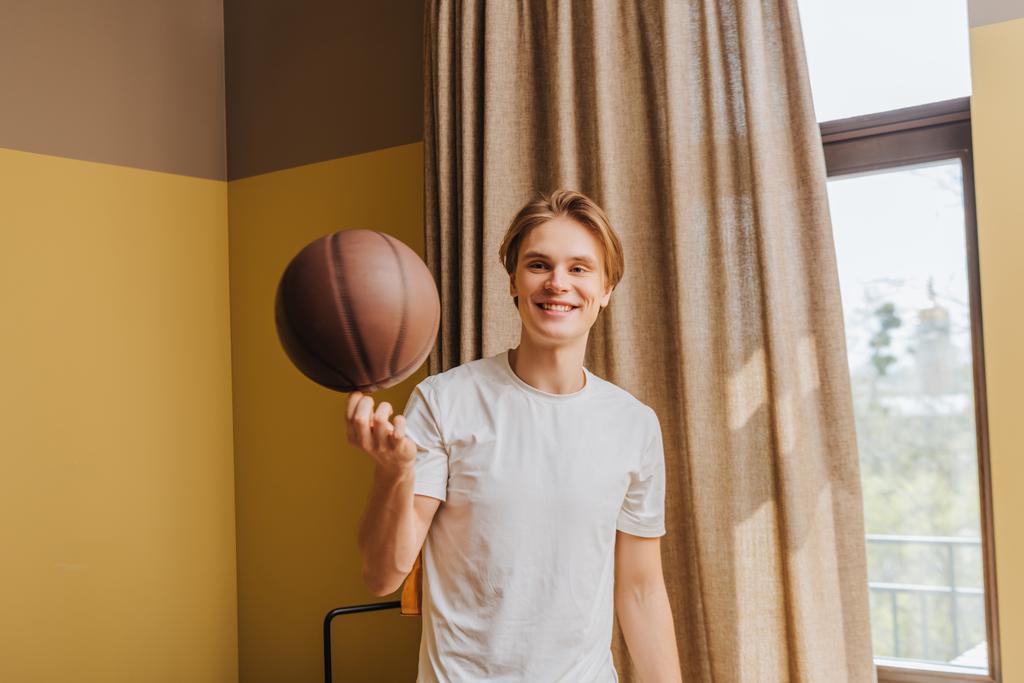 enfoque selectivo del hombre feliz mirando baloncesto en casa, fin del concepto de cuarentena
 - Foto, imagen