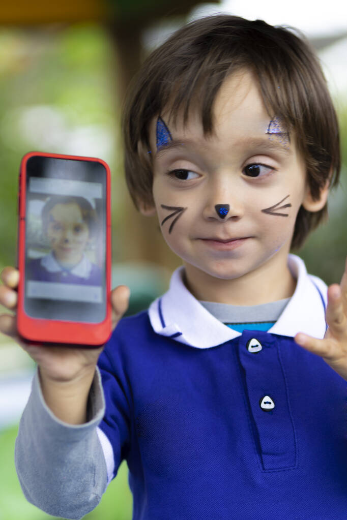 Lovely Boy with Painted Face, Playing on Mobile Phone - Photo, Image