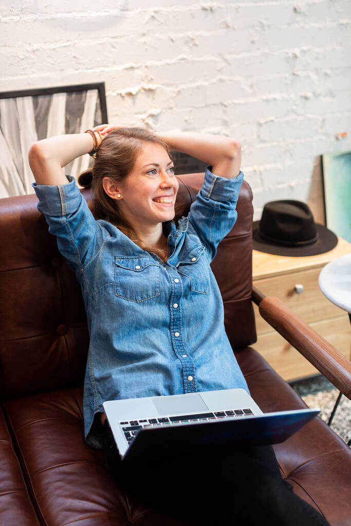 Розслаблена весела жінка з ноутбуком на дивані
 - Фото, зображення
