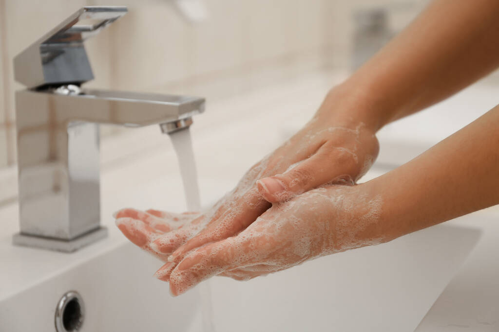 Donna che si lava le mani con sapone antisettico in bagno, primo piano. Prevenzione del virus
 - Foto, immagini