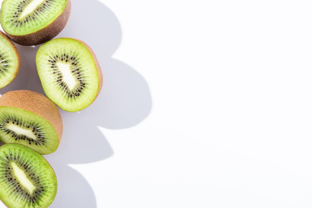 vrchní pohled na čerstvé a zelené kiwi ovoce půlky na bílém  - Fotografie, Obrázek