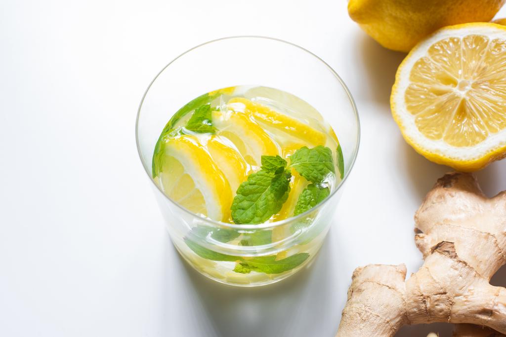 свежий лимонад в стакане рядом с лимоном и корень имбиря на белом фоне
 - Фото, изображение