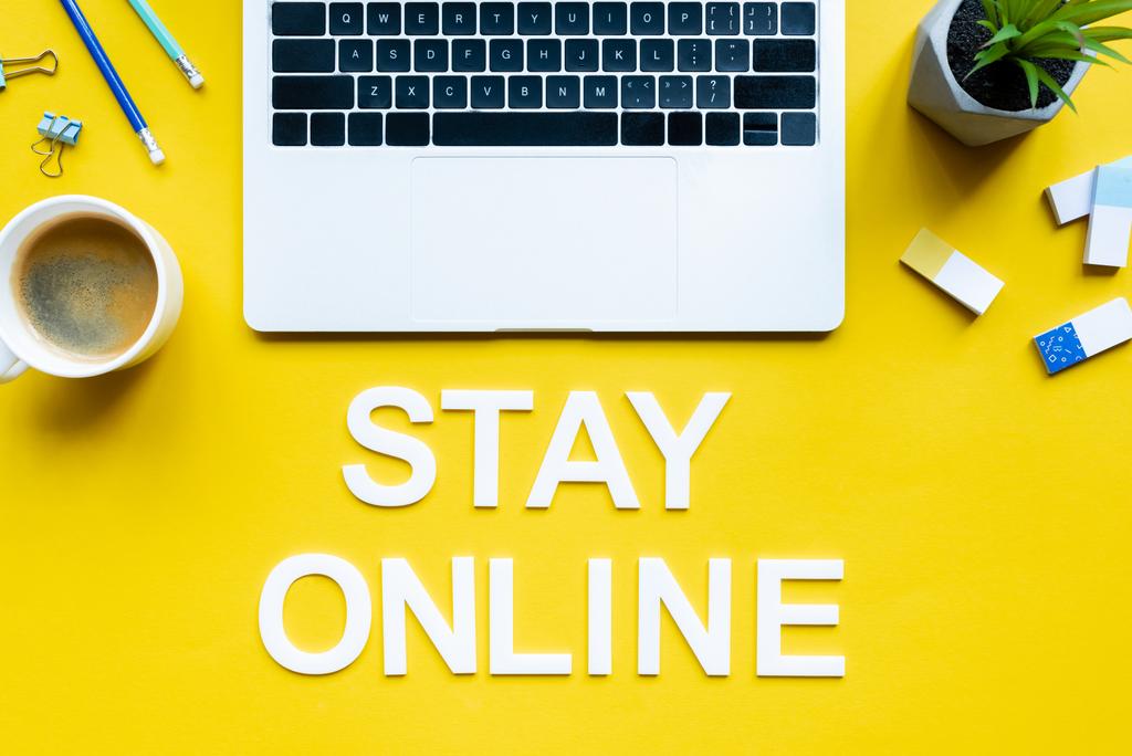Top kilátás bettering maradjon online közelében laptop, csésze kávé és irodai kellékek sárga felületen - Fotó, kép