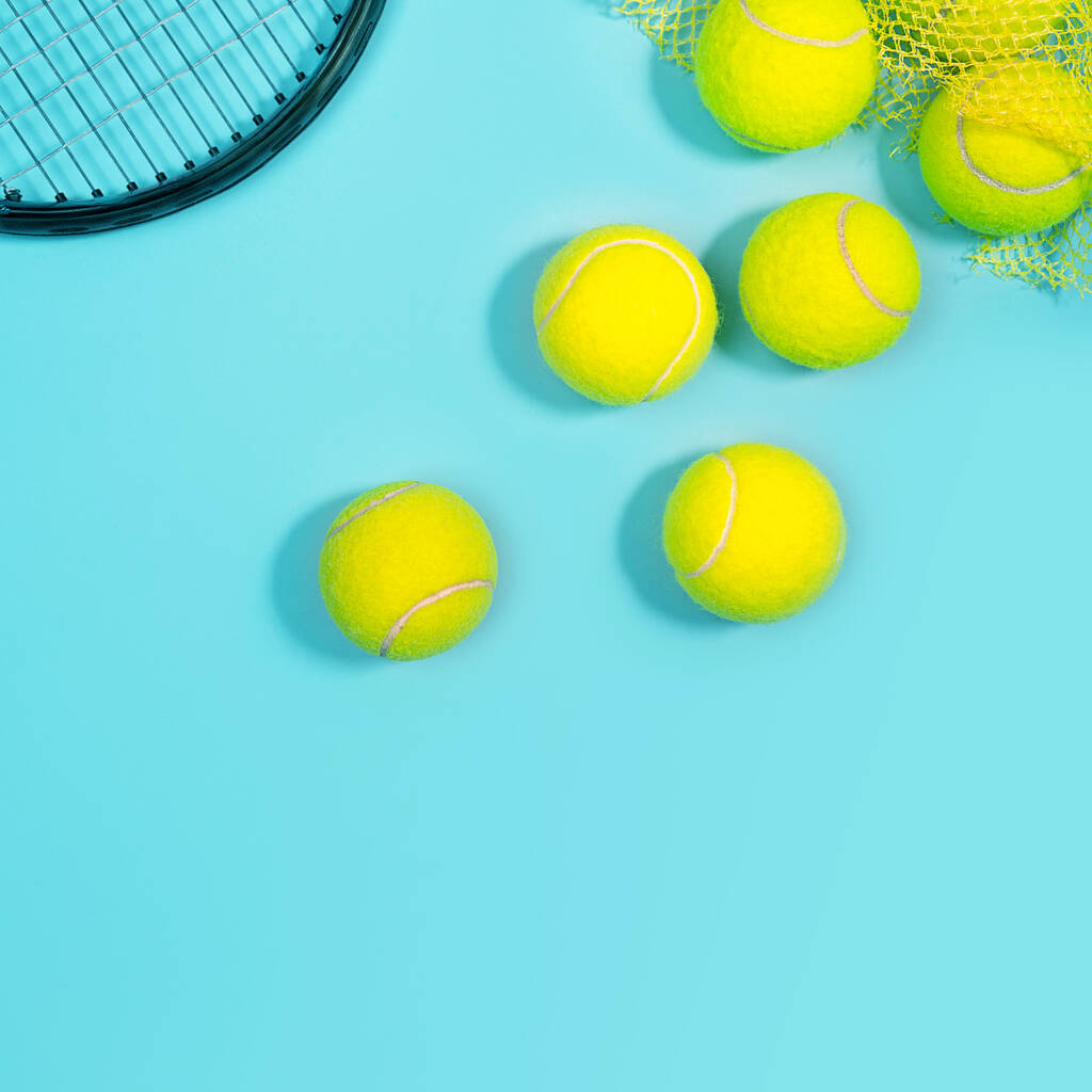 Pelotas de tenis y raqueta de cerca en la pista de tenis azul
.  - Foto, imagen