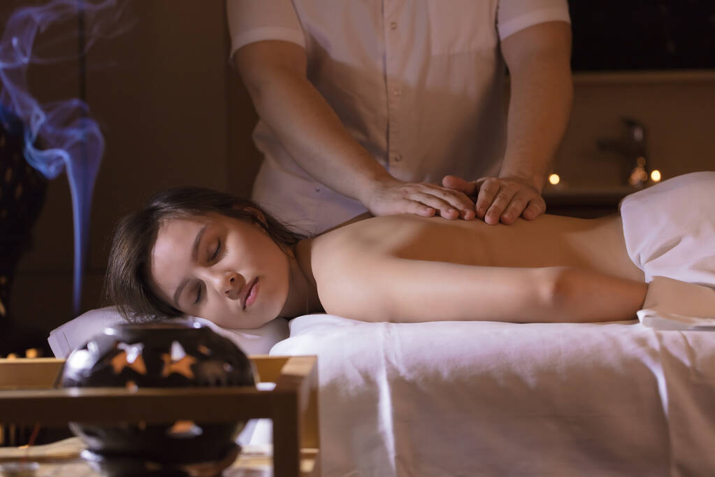 Hermosa chica en un salón de masajes para tratamientos de salud de espalda y aromaterapia
 - Foto, imagen
