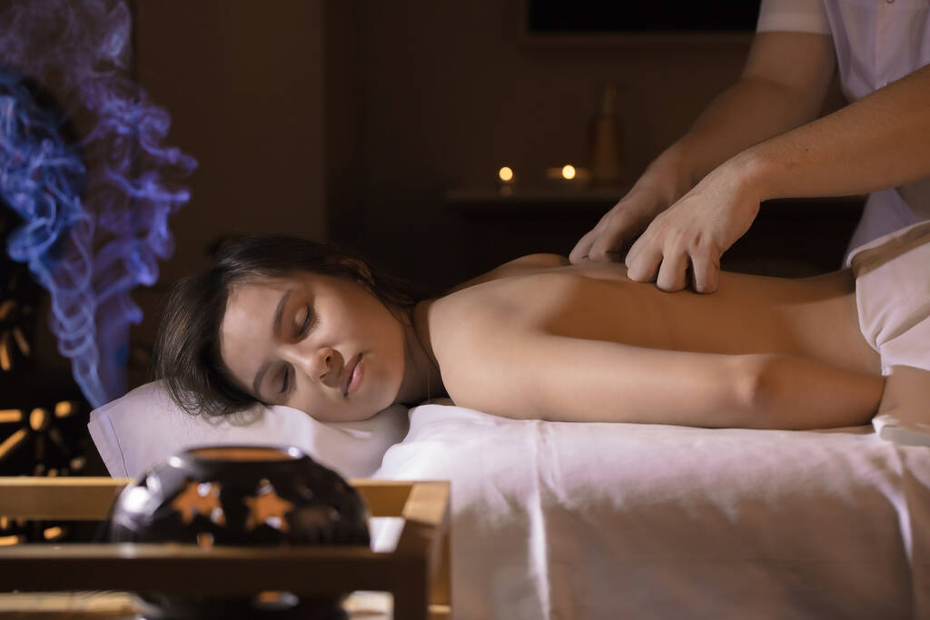 Schöne Mädchen in einem Massagesalon für Rückenbehandlung und Aromatherapie - Foto, Bild