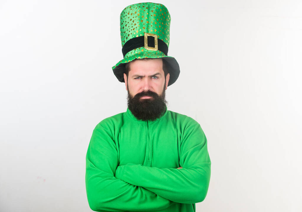 Bycie poważnym w dzień świętych Patricków. Hipster w karłowatym kapeluszu i kostiumie trzymający skrzyżowane ramiona. Irlandczyk z brodą w zieleni. Człowiek z brodą świętujący Dzień Świętego Patryka. Brodaty i brutalny - Zdjęcie, obraz