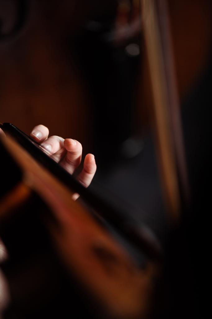 обрізаний вид професійного музиканта, який грає на скрипці на темній сцені
 - Фото, зображення