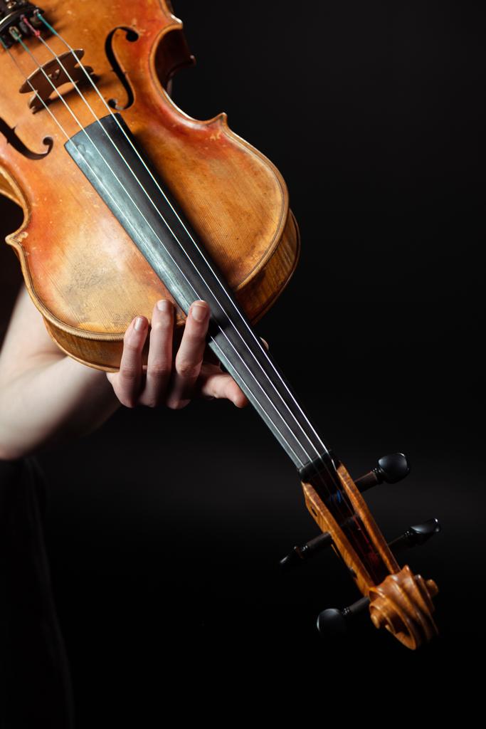 bijgesneden mening van vrouwelijke muzikant spelen symfonie op viool geïsoleerd op zwart - Foto, afbeelding