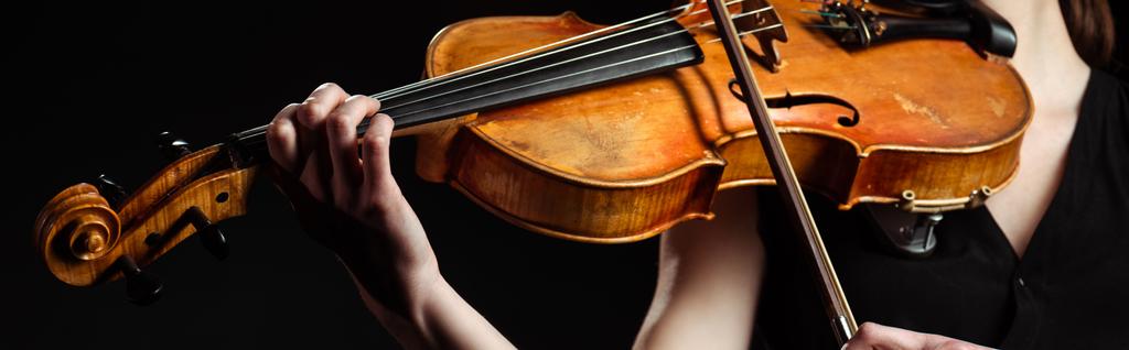 visão parcial do músico feminino tocando violino isolado em preto, imagem horizontal
 - Foto, Imagem