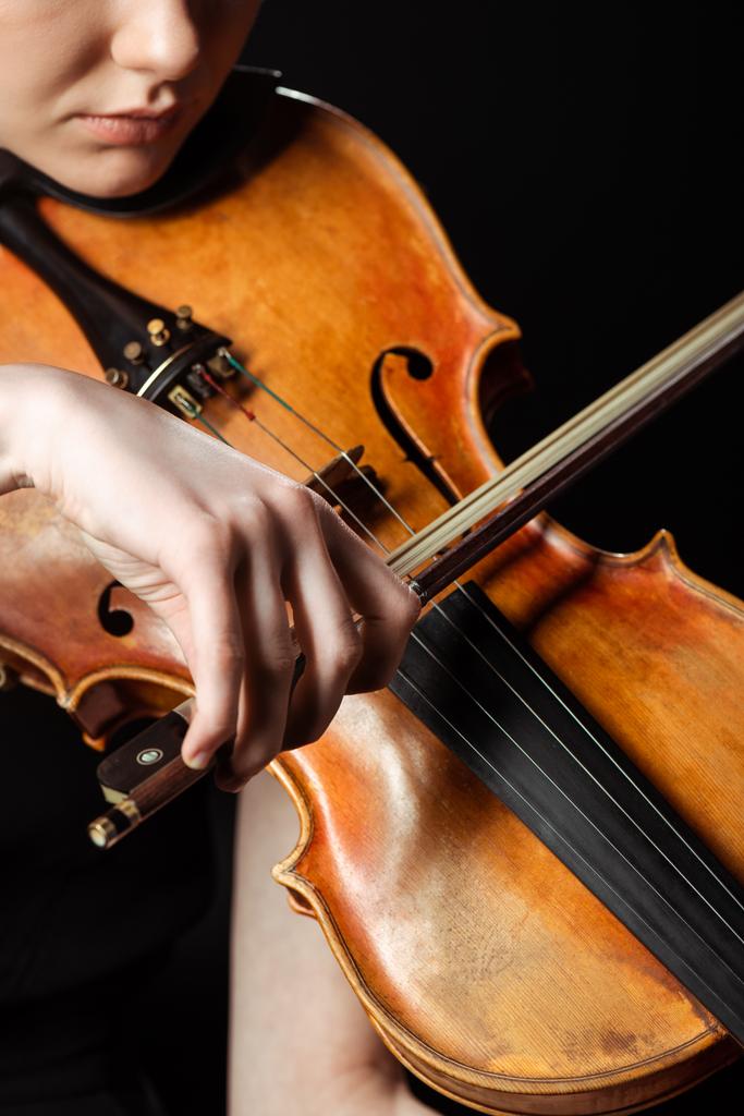 vista parcial del músico profesional tocando el violín aislado en negro
 - Foto, imagen