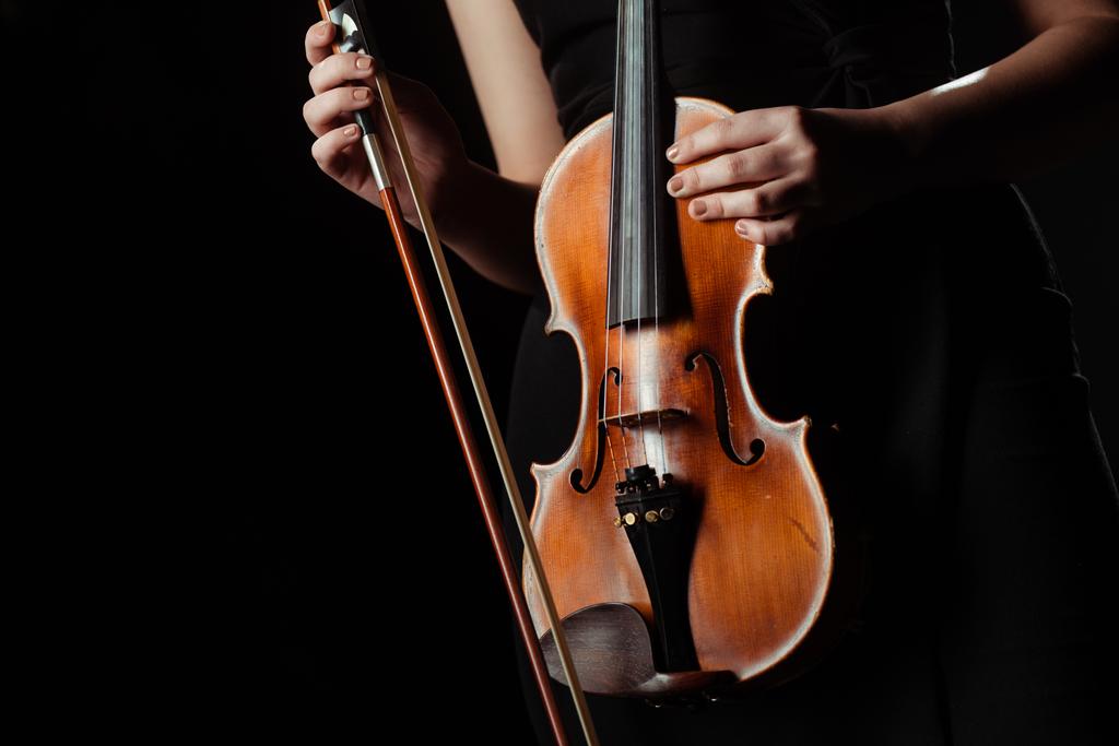 Vista parcial del músico sosteniendo violín aislado sobre negro
 - Foto, imagen