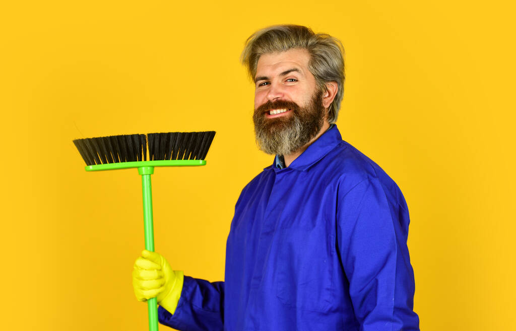 Cleaning day. Cleaning agency. Worker with brush. Cleaning equipment. Yardman occupation. Bearded hipster blue uniform with broom. Gardener cleaning service man. Garbage removal. Janitor professional - Photo, Image