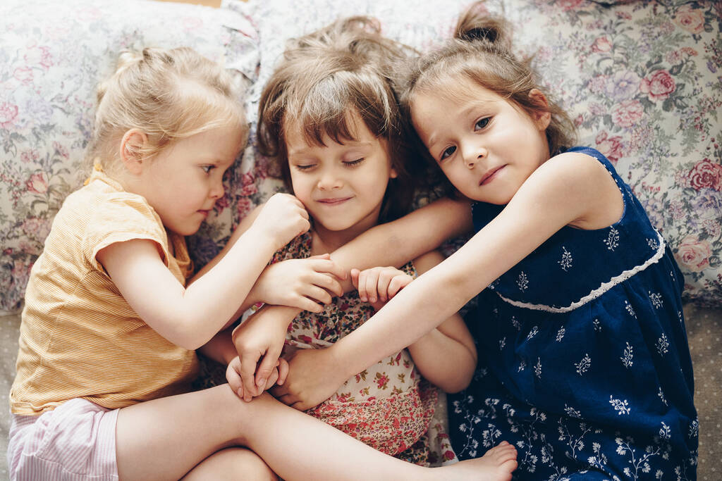 Tres hermanas yacen lado a lado en la cama - Foto, Imagen